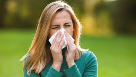 A young woman is suffering from a runny nose, one of the most common signs of seasonal allergies